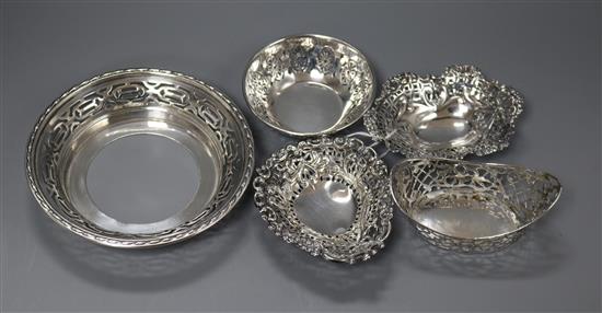 Four assorted pierced silver bonbon dishes and one other pierced silver dish.